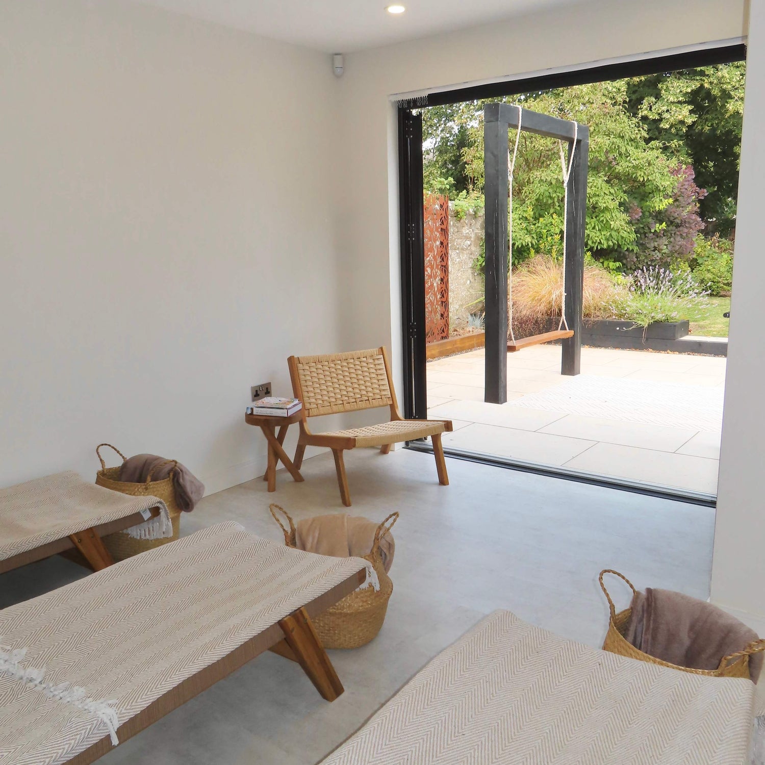 Modern interior with wooden furniture and a large glass door leading to an outdoor area. Fresh Inc Medispa