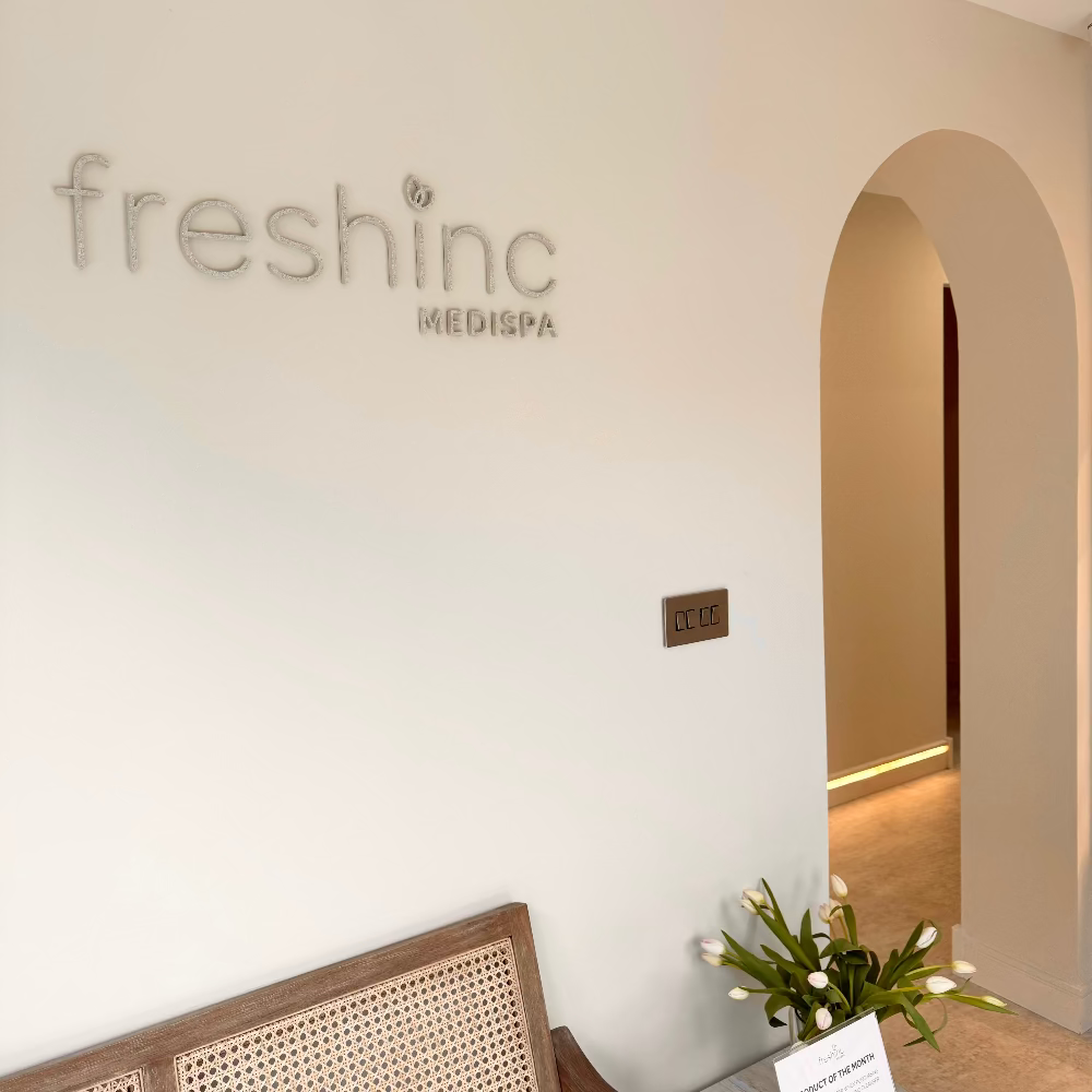 Wall with 'freshinc MEDISPA' logo and a flower arrangement on a chair. specialist aesthetic injections and spa